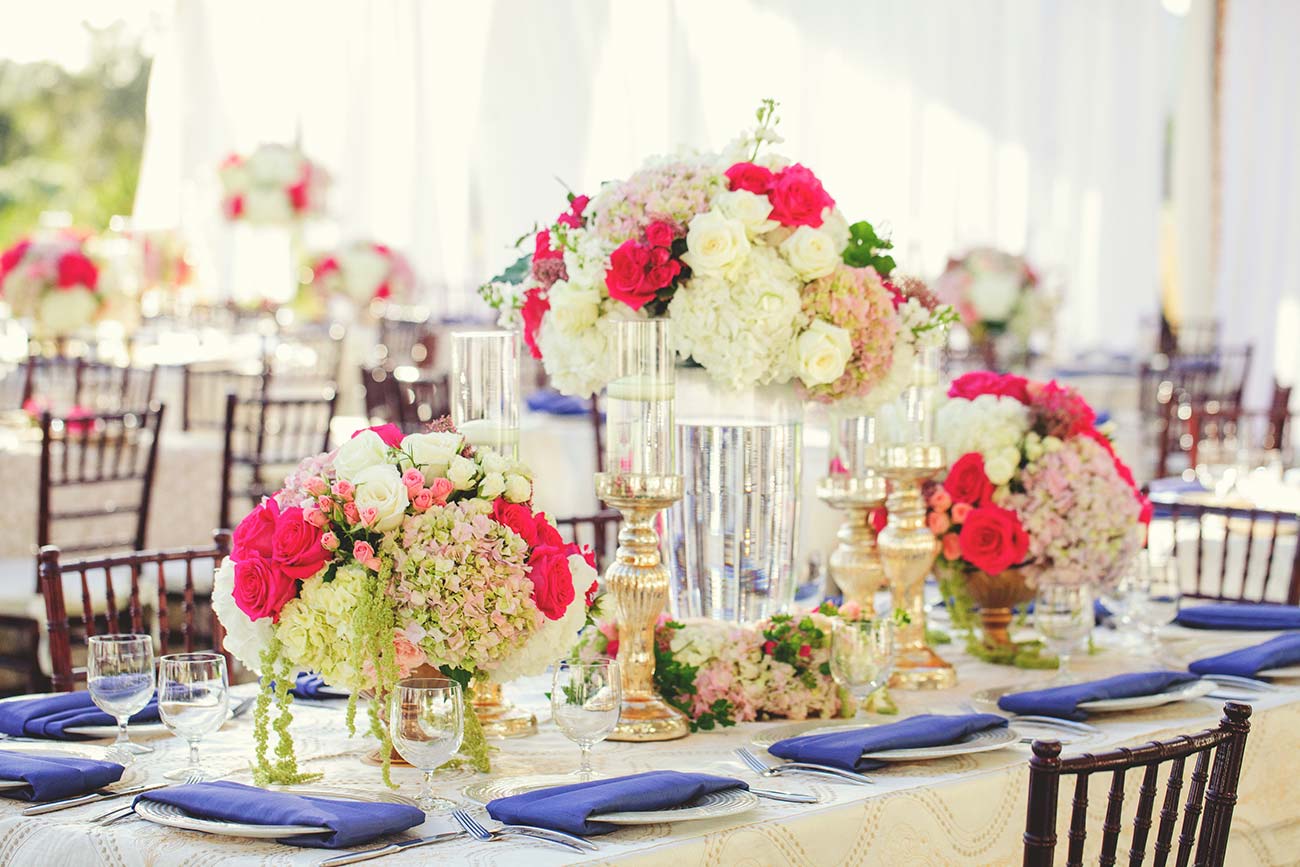 Wedding reception table top design with floral arrangements, dinnerware and candles