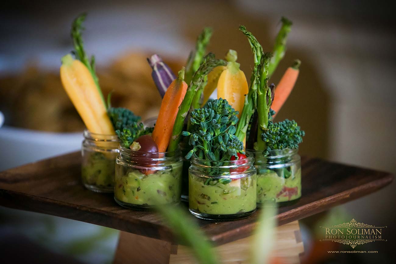 Guacamole appetizers in small glass jars with small vegetables