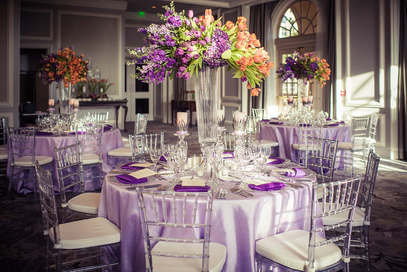 Reception room with tabletop designed linens, crystal, florals and dinnerware