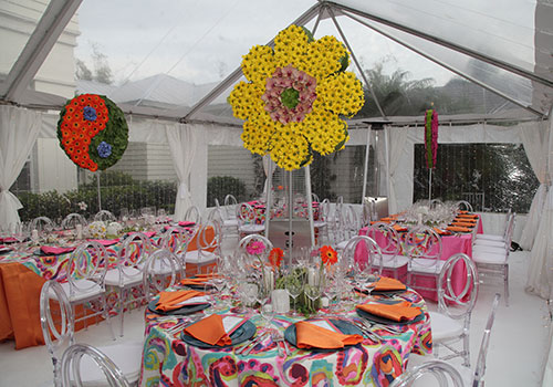 Tabletop design using a 60's inspired design with giant bright flowers, bright colors in an indoor tent