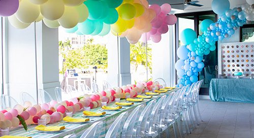 Tabletop design with ghost chairs, balloon canopy in rainbow colors designed for a Sweet 16 birthday party