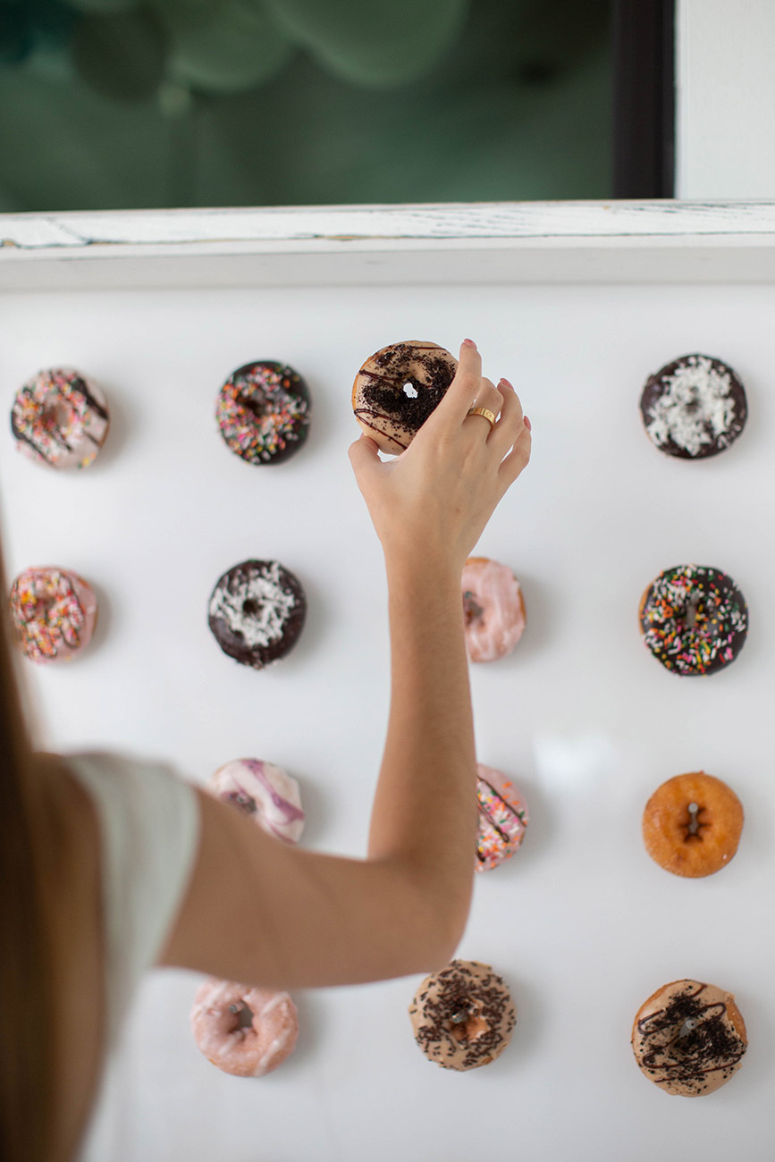 Teenager selecting a doughnut from a doughnut wall display